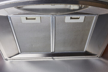 Stainless Steel Chimney Hood with two sections of metal grid. Cooker Hood. Horizontal photo, angle view.
