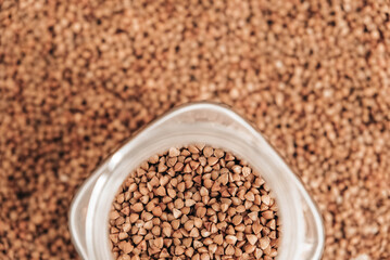 Buckwheat in a glass jar on a background of cereals. Top view. Copy, empty space for text