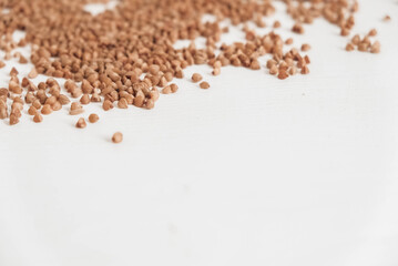 Buckwheat is randomly scattered on a white background. Top view. Copy, empty space for text