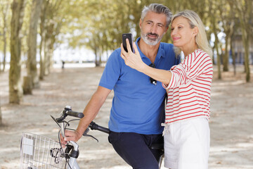 senior couple with smartphone outside in spring nature