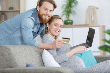 happy couple using laptop and credit card