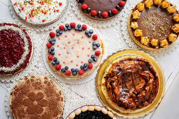 selection of cheesecakes, profiterole, carrot cake, tartlet, fruit cakes for mothersday, valentines day on white background