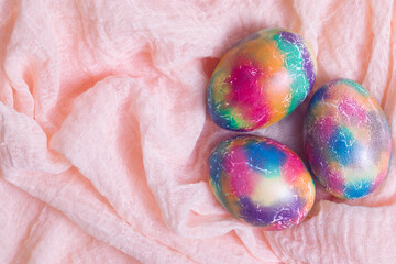 Festive Easter eggs, background from the texture of bright yellow viscose fabric, top view, flat lay.