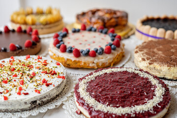 selection of cheesecakes, profiterole, carrot cake, tartlet, fruit cakes for mothersday, valentines day on white background