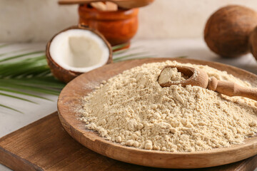 Plate with coconut flour on light background