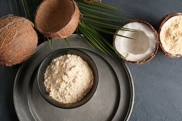 Bowl with coconut flour on dark background