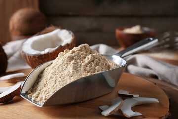 Scoop with coconut flour on wooden background