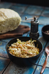 Salad with cabbage, eggs, corns and meat on the plate on rustic tiled table