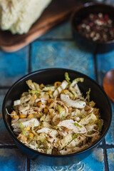 Salad with cabbage, eggs, corns and meat on the plate on rustic tiled table