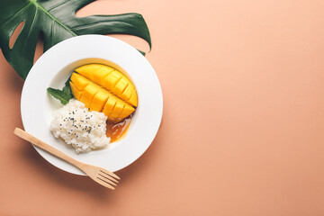 Plate with tasty rice and mango on color background