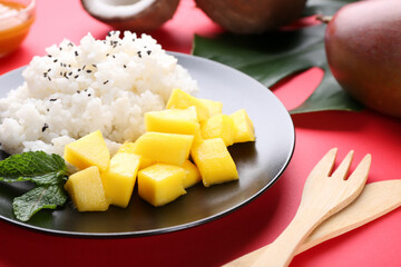 Plate with tasty rice and mango on color background, closeup