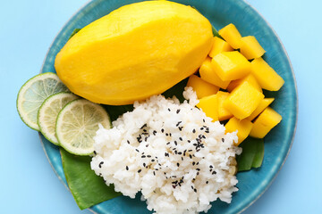 Plate with tasty rice, mango and lime on color background, closeup