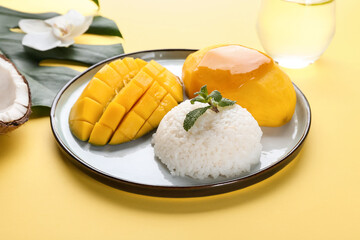 Plate with tasty rice and mango on color background