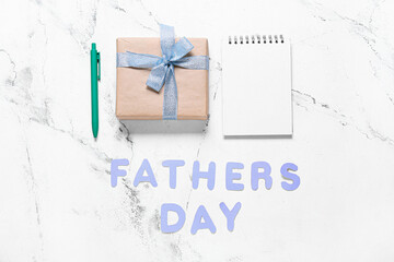 Composition for Father's Day with gift and notebook on light background