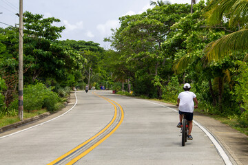 Fototapeta premium person riding a bike in a long way