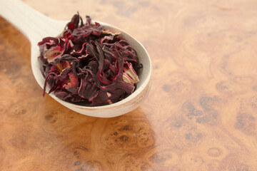 Red tea in a wooden spoon on a wooden background