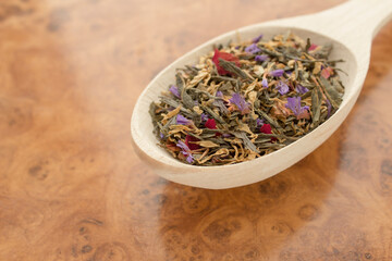 Tea in a wooden spoon on a wooden background