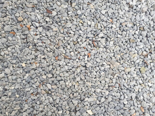 Gravel texture. Pebble stone background. Light grey closeup small rocks. Top