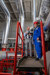 Smiling Manager With Digital Tablet Standing Next to Worker in Power Plant