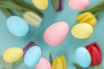 Fototapeta na wymiar Easter background. Levitating Easter eggs and tulips in pastel colors on a blue background. composition Easter greeting card, pattern
