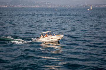 A speedboat rushes through Lake Garda, Northern Italy
