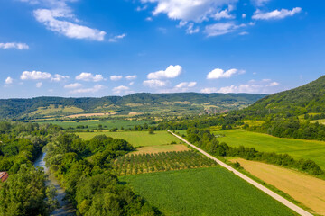 Fototapeta na wymiar Aerial view from drone of the vast green landscape with river and hills