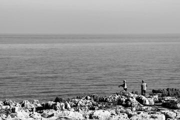 Adriatic sea fishermen on the edge of the rocks