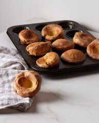 Yorkshire Puddings in baking dish. Homemade Traditional fluffy golden Yorkshire Puddings.