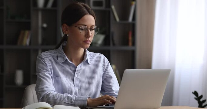 Concentrated tired young business lady working on computer at home office, taking off eyewear, suffering from eyestrain or dry eyes syndrome, having blurred vision, needs rest, laptop overwork concept