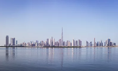 Foto op Canvas Dubai Downtown skyline panorama met reflecties in Dubai Creek, koude kleuren, gezien vanaf Dubai Creek Harbor promenade. © Cleop6atra