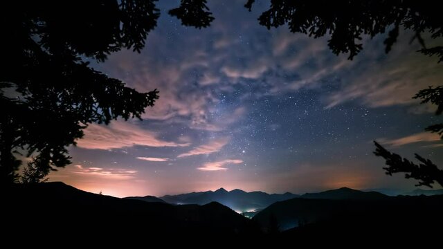 Blue night with milky way galaxy stars and clouds sky in forest mountains nature landscape Astronomy time lapse