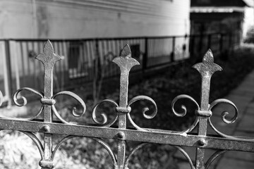 Ancient forged elements of a metal fence in dark colors