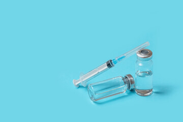 syringes and ampoules with vaccinations on a blue background. vaccination against covid-19. the...