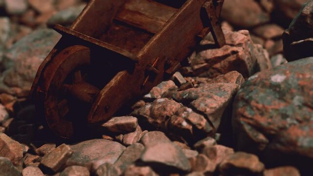 abandoned wooden mine wheelbarrow on rocks