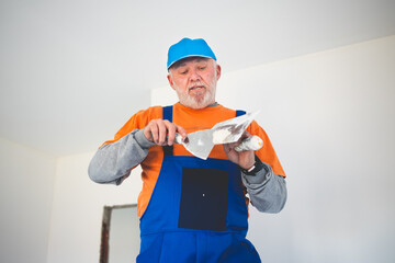 Painter,preparing the wall for painting while standing on ladder