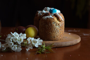 Easter, holidays and tradition concept. Easter cake. Colorful Easter eggs painted in pastel colors and blossom cherry.