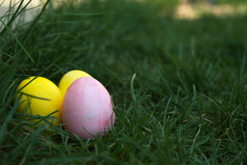 Fototapeta premium Easter, holidays and tradition concept. Colorful Easter eggs painted in pastel colors on green grass background.