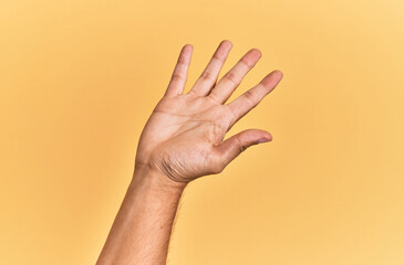 Arm and hand of caucasian man over yellow isolated background presenting with open palm, reaching for support and help, assistance gesture