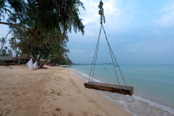 hanging wooden timber swing at blue sea beach, Tapao beach in Koh Kood island, Thailand