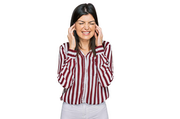 Obraz na płótnie Canvas Beautiful brunette woman wearing striped shirt covering ears with fingers with annoyed expression for the noise of loud music. deaf concept.