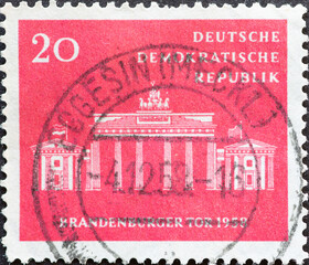 GERMANY, DDR - CIRCA 1958 : a postage stamp from Germany, GDR showing the Brandenburg Gate. 10 years Magistrate of Greater Berlin. red