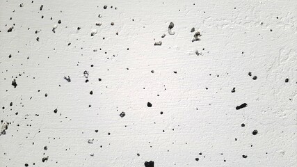 Light concrete wall with black dots. Wall texture background