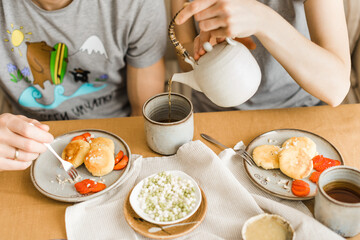 Women pouring black tea into a ceramic mug