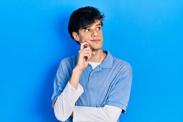 Handsome hipster young man wearing vintage look thinking concentrated about doubt with finger on chin and looking up wondering
