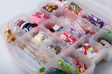 Close up shot of beads organizer or container for buttons, sewing and embroidery. Multicolored set of materials for handcraft, making of bijouterie and accessories.