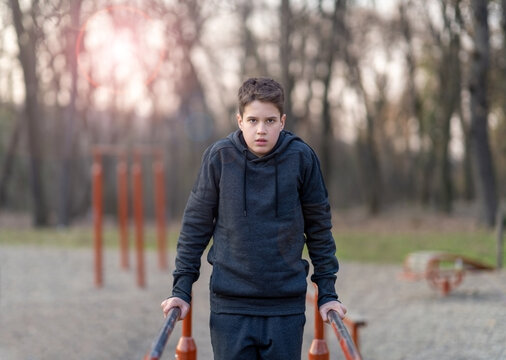 Determined young man doing dips on parallel bars at an outdoor gym.Doing exercise on parallel bars.Lifestyle photos.
