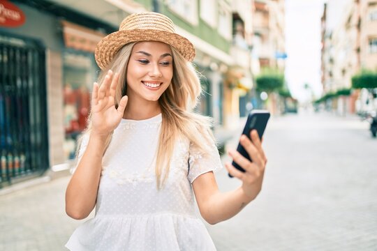 Young caucasian tourist girl doing video call using smartphone at city.