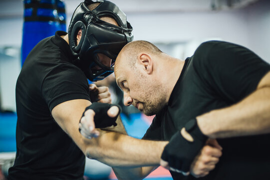 Instructor demonstrate headbutt street fight technique against attacker. Head kick