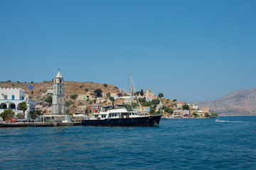 Fototapeta na wymiar View of colorful Symi island with a big black ship. Symi, Dodecanese, Greece
