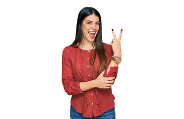 Young hispanic woman wearing casual clothes smiling with happy face winking at the camera doing...